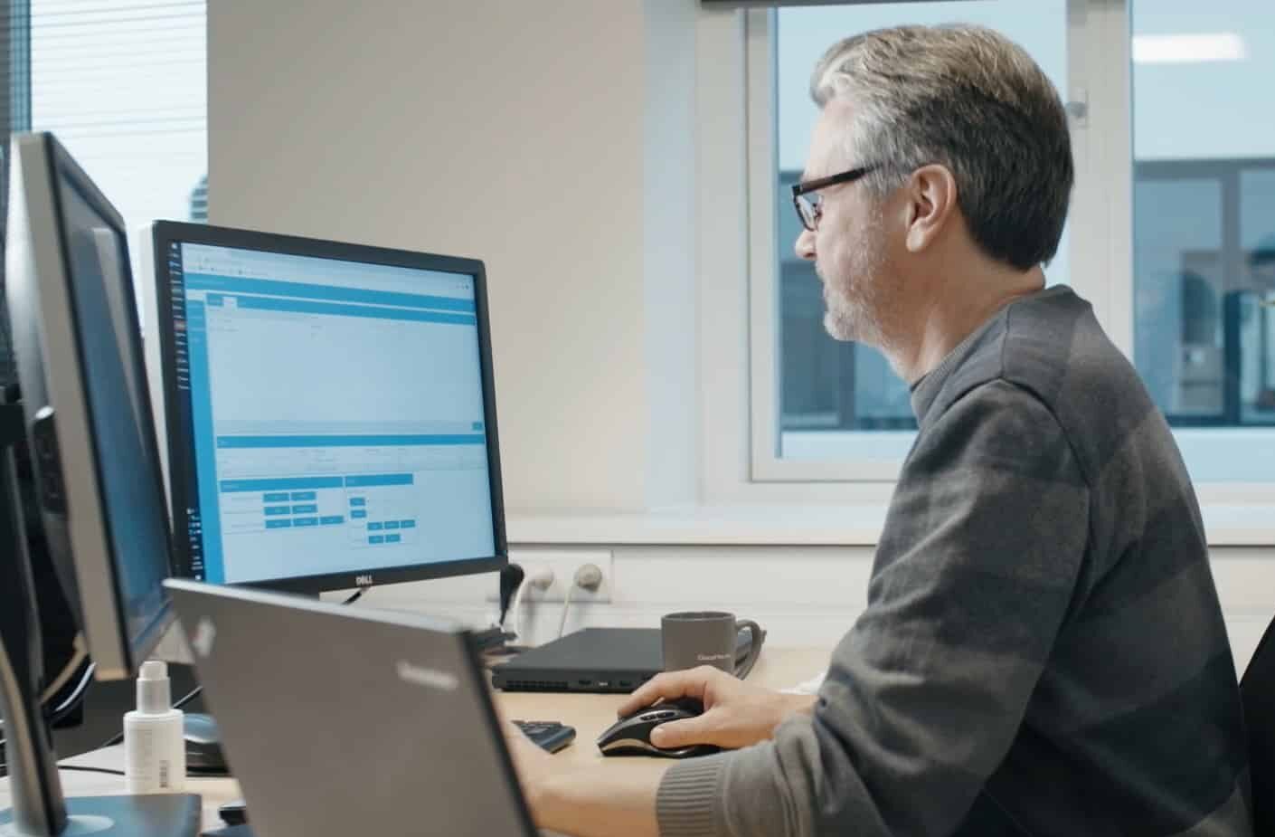 Man working on computer in office setting.