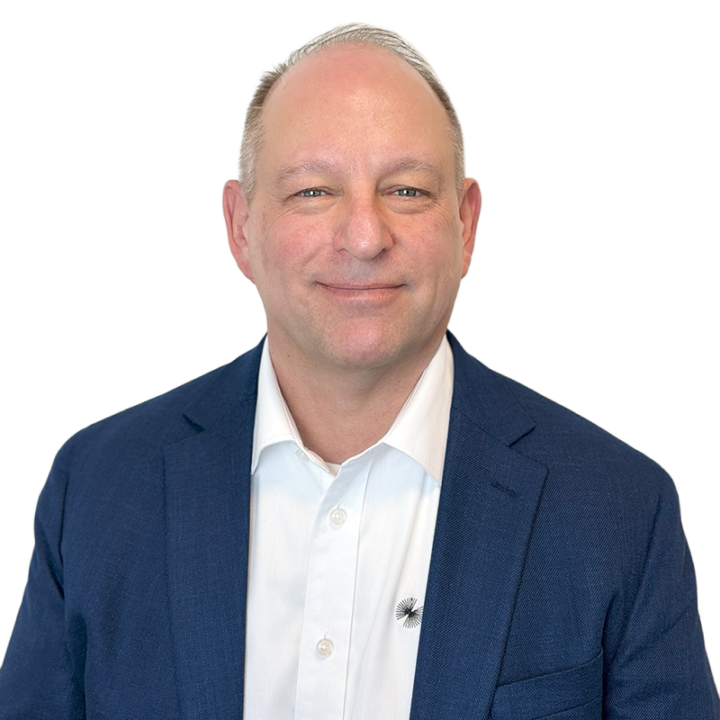 Man in blue suit smiling at camera.